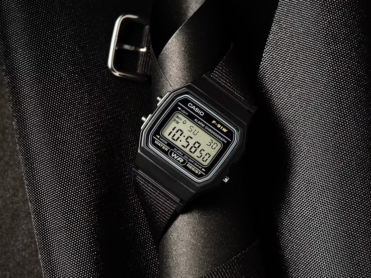 Casio F-91WF-1A digital watch with a black case, black woven fabric strap, and silver accents, photographed against a dark textured background.