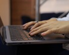Hands typing on the keyboard of a dark laptop