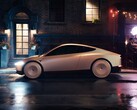 Tesla Cab parked on a wet city street at night, featuring a sleek, futuristic design with covered wheels. (Image source: Tesla)