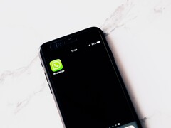 Smartphone on a white table showing the WhatsApp app