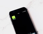 Smartphone on a white table showing the WhatsApp app