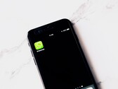 Smartphone on a white table showing the WhatsApp app