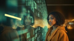 A woman is looking at a large screen displaying various data. (Image source: Freepik.com)