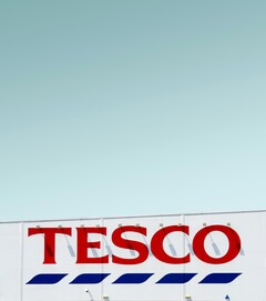 Tesco exterior signage photographed against a clear sky (Image source: Simone Hutsch via Unsplash)