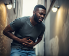 A black man clutching his abdomen (Image source: AI-generated image)