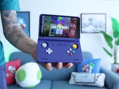 Retro Game Corps’ Russ holding the Retroid Pocket Flip 2 handheld gaming console in purple, with the screen displaying a Sega Genesis emulator interface. (Image source: Retro Game Corps on YouTube)