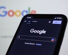 Smartphone showing the Google search page in front of a screen with the Google logo