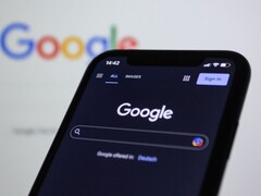 Smartphone showing the Google search page in front of a screen with the Google logo