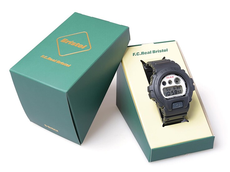 Casio G-Shock x F.C. Real Bristol DW-6900 displayed inside a green co-branded presentation box with the matching outer sleeve beside it.
