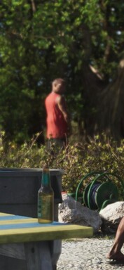 A man appears to be relieving himself against a tree (zoomed-in GTA 6 screenshot).