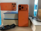 Apple iPhone 17 Air in orange finish showing rear design and camera module placed on stacked books