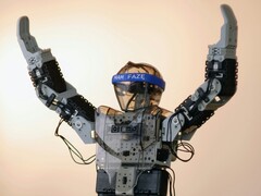 A humanoid robot with its arms in the air (Image source: Adam Lukomski via Unsplash; cropped)