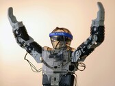 A humanoid robot with its arms in the air (Image source: Adam Lukomski via Unsplash; cropped)