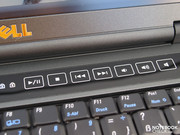Touch-sensitive multimedia buttons are positioned above the keyboard.