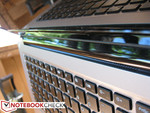 Speaker grilles between the base and display hinge