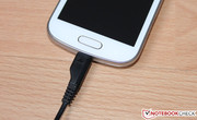 the included charging cord at the micro USB port.