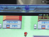 Close-up of the transparent-blue FPGBA SP handheld running Pokémon, with a 59.74 FPS counter visible.