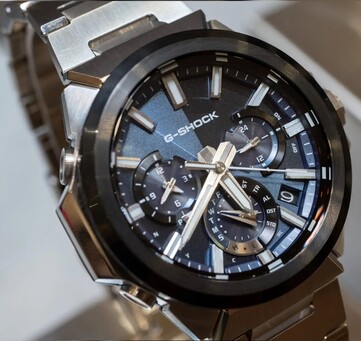 Close-up of the blue-dial Casio G-Shock GST-W1000AD-2A, showing its layered three-subdial layout, luminous markers, silver hands, and black bezel.