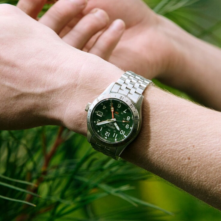 Front view of the Seiko 5 Sports Field GMT HDB001 featuring a green dial, fixed stainless steel 24-hour bezel, orange GMT hand, and five-link steel bracelet.