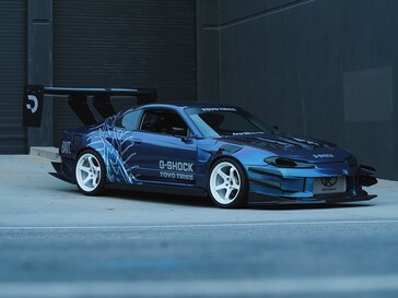 Blue drift car featuring G-Shock and Toyo Tires graphics parked outside an industrial building.