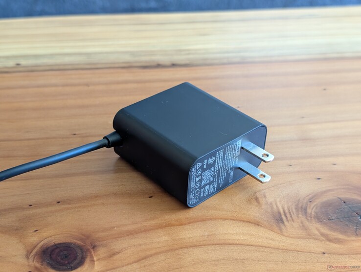 65 W USB-C AC adapter that ships with the Lenovo Yoga Slim 7 14. Note the un-retractable AC prongs and the integrated USB-C cable on the other end