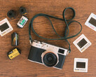 The developer's new feature for Fujfilm cameras will be built into the existing Fujistyle app. Pictured - the Fujfilm X100V camera alongside various film rolls. (Image source: Fuji X Weekly)