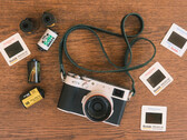 The developer's new feature for Fujfilm cameras will be built into the existing Fujistyle app. Pictured - the Fujfilm X100V camera alongside various film rolls. (Image source: Fuji X Weekly)