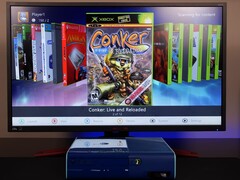 A modded blue Xbox 360 running a custom homebrew dashboard on a monitor, displaying the game “Conker: Live and Reloaded” alongside other Xbox and emulator titles. (Image source: Modern Vintage Gamer on YouTube)