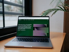 Laptop on a desk by a window with the OpenAI ChatGPT website open on the screen