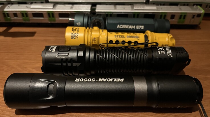 Loop Gear's yellow SK-07 compared with the Acebeam E75 (rear), Nitecore P27i, and Pelican 5050R