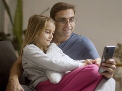 A father and his daughter looking at a smartphone together