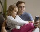 A father and his daughter looking at a smartphone together