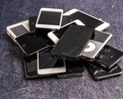 Heap of retired smartphones on a grey surface
