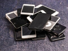 Heap of retired smartphones on a grey surface
