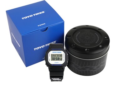 Casio G-Shock DW5600TT25-1 watch displayed with its blue Toyo Tires box and custom metal tin.