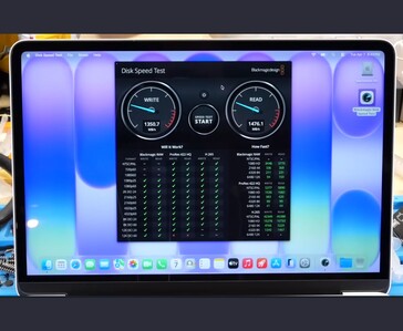 MacBook Neo displaying Blackmagic Disk Speed Test results with ~1350 MB/s write and ~1476 MB/s read speeds on the stock 256 GB SSD
