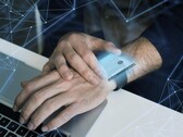 A smartwatch near a computer, hinting at potential security risks (Image source: Freepik)