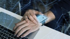 A smartwatch near a computer, hinting at potential security risks (Image source: Freepik)