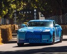The Jaguar Type 01 EV in Blue Exuberant Modernism Camouflage zooming past the starting grid in Goodwood Hill Climb