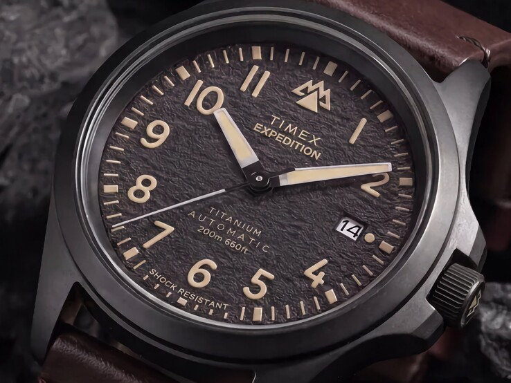 Close-up of the Timex Expedition Field Post Titanium’s textured black dial with Arabic numerals, luminous hands and markers, and date window.